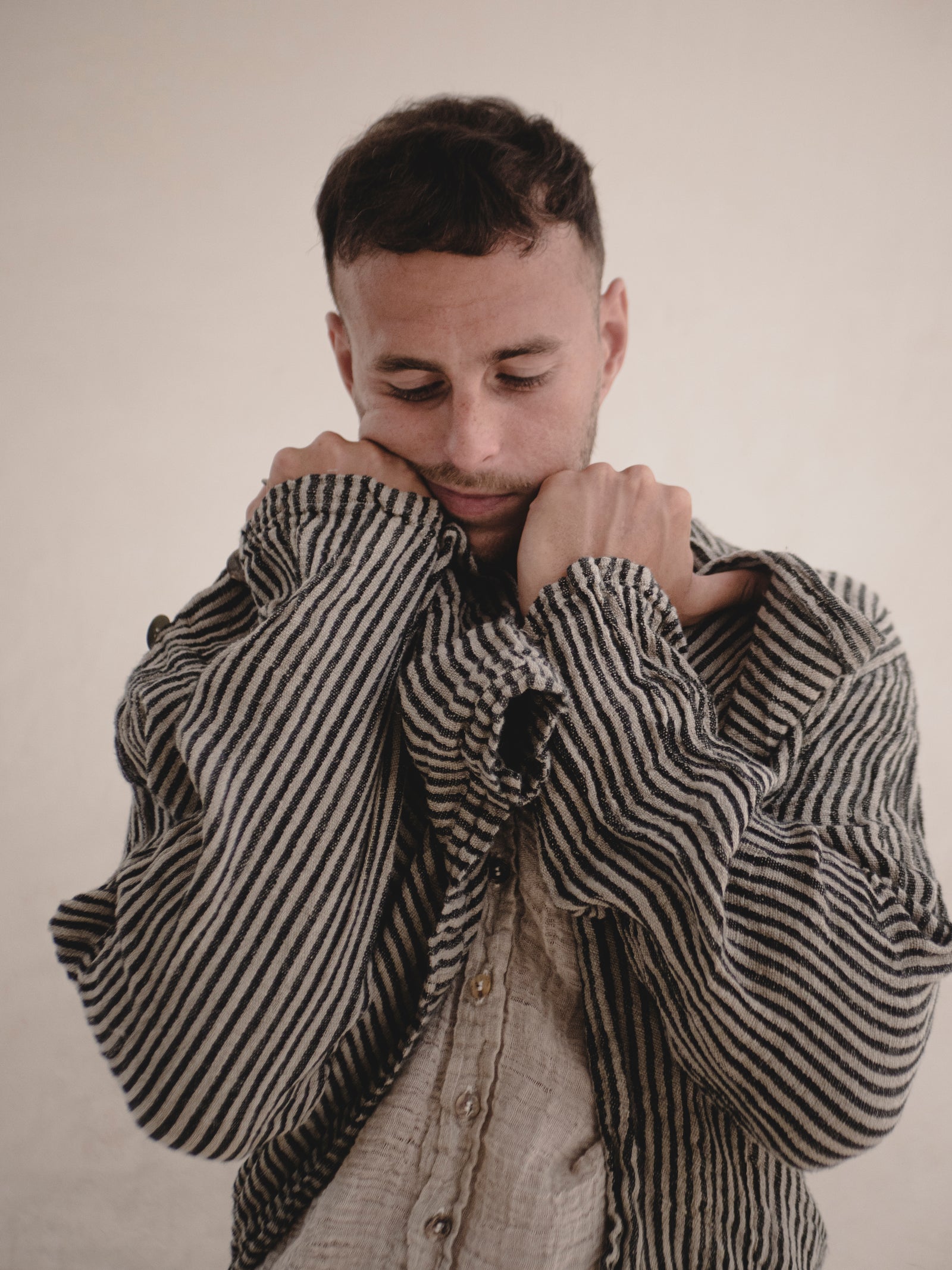 Man wearing a striped jacket against a plain background