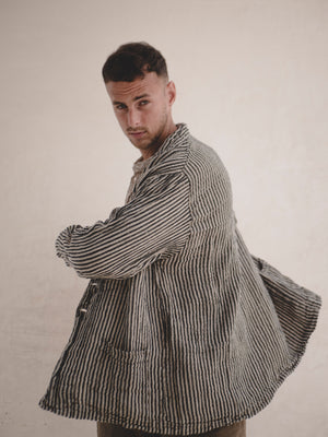 Man wearing a striped blazer against a plain background