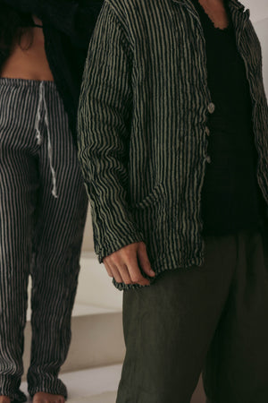 Person wearing a striped jacket and pants in an indoor setting