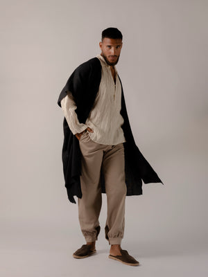 Minimal linen cape for men designed for warm-weather layering.