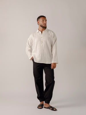 man wearing a Traditional tailoring pants, with a pleated front and tapered ankles that tie.