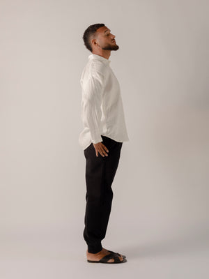 man wearing a Traditional tailoring pants, with a pleated front and tapered ankles that tie.