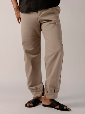man wearing a Traditional tailoring pants, with a pleated front and tapered ankles that tie.