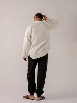 man wearing a black Traditional tailoring pants, with a pleated front and tapered ankles that tie.