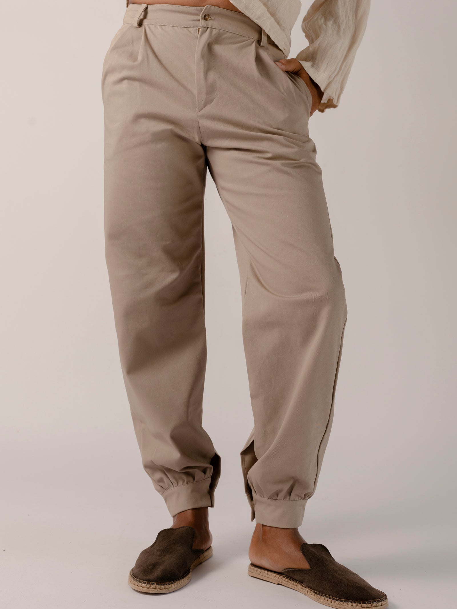 man wearing a Traditional tailoring pants, with a pleated front and tapered ankles that tie.
