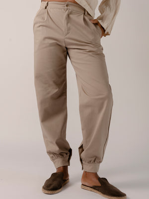 man wearing a Traditional tailoring pants, with a pleated front and tapered ankles that tie.