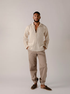 man wearing a Traditional tailoring pants, with a pleated front and tapered ankles that tie.