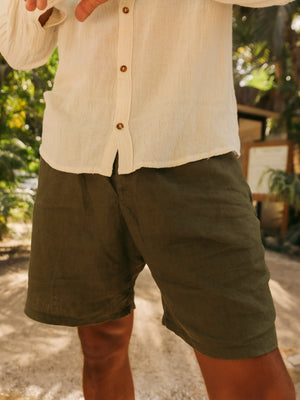 Person wearing a beige shirt and olive shorts outdoors