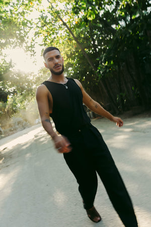 A model wearing black classic fit straight-line trousers with pockets on the sides and behind, and subtle pleat detailing from the waistband.
