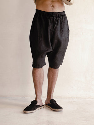 man wearing a linen black oversized bermuda shorts