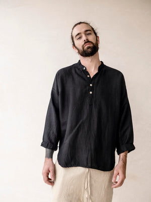 Man wearing a black linen shirt with  loose fit and mandarin collar