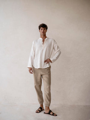 A pair of men's linen jogger pants in khaki, with an elasticized drawstring waist and side pockets. 