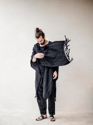 Oversized black cotton cape poncho for men with hand-finished fringe. Lightweight breathable cover up for beachwear, vacations and relaxed resort style.