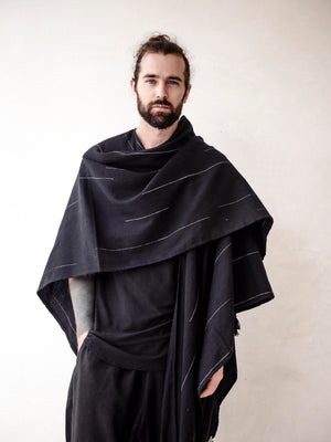Oversized black cotton cape poncho for men with hand-finished fringe. Lightweight breathable cover up for beachwear, vacations and relaxed resort style.