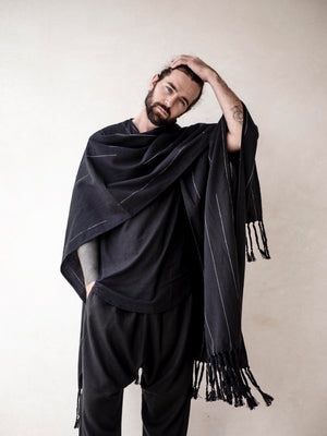 Oversized black cotton cape poncho for men with hand-finished fringe. Lightweight breathable cover up for beachwear, vacations and relaxed resort style.